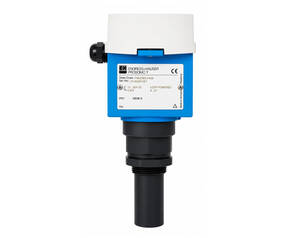Industrial optical sensor with blue housing, white protective cap on top, and black cable gland at the bottom, used to detect objects on a production line.
